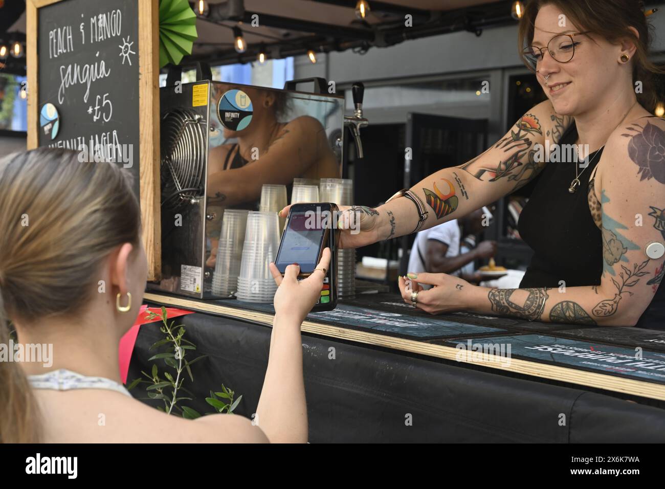 Payment by tap and go, customer using smartphone payment for purchase Stock Photo