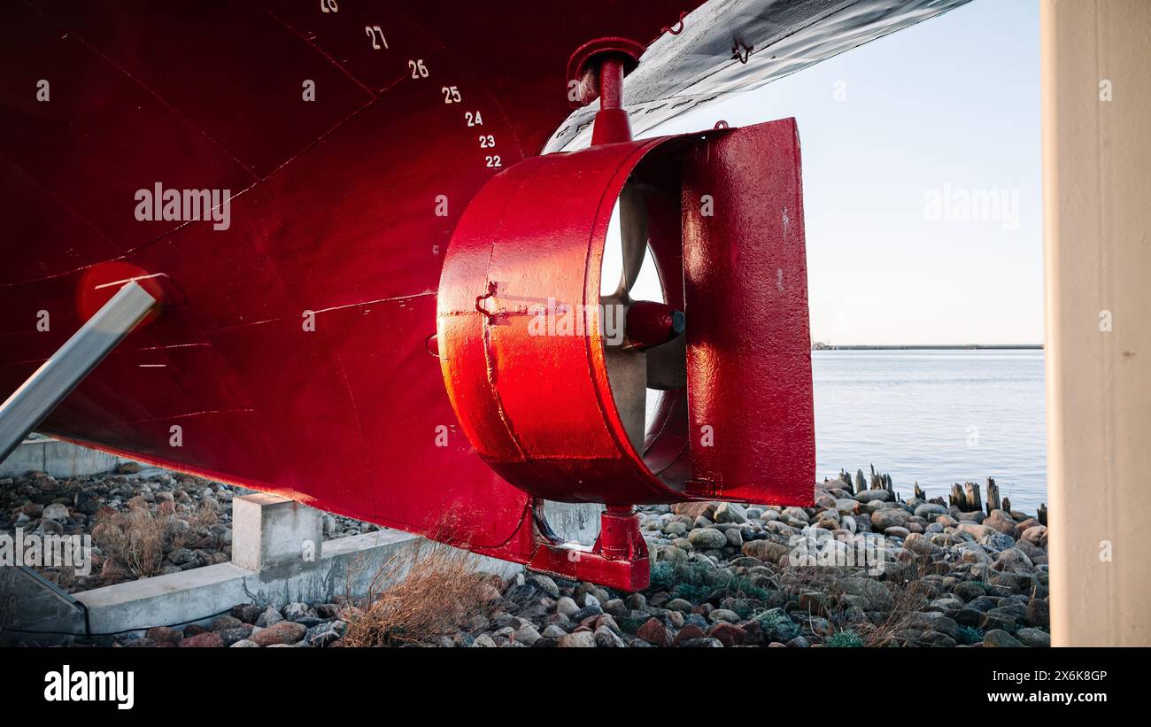 A red propeller is on the side of a boat Stock Photo