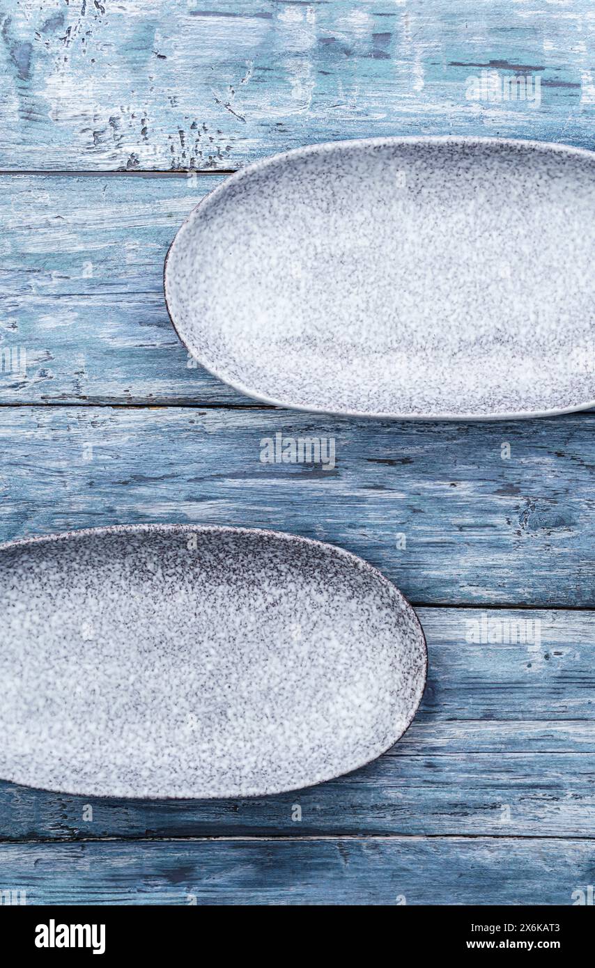 Two empty oval plates on old rustic wooden table. Top view, with copy space Stock Photo