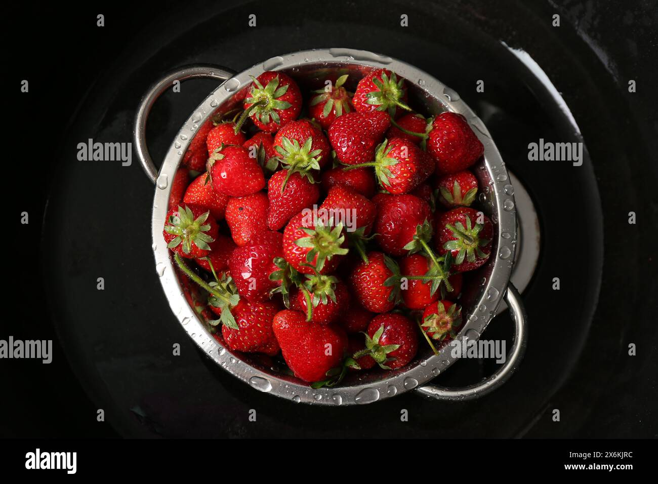 Metal colander with fresh wet strawberries in sink, top view Stock ...