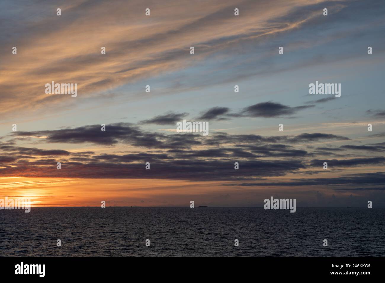 sunset, with a cloudy sky, over the ocean Stock Photo
