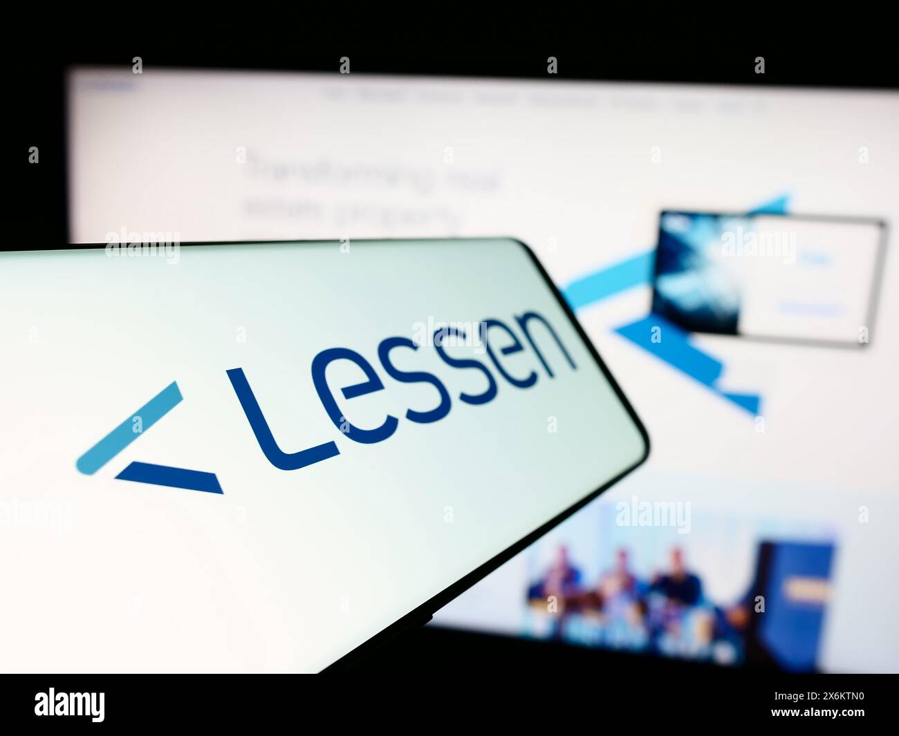 Smartphone with logo of American property services marketplace company Lessen Inc. in front of business website. Focus on left of phone display. Stock Photo