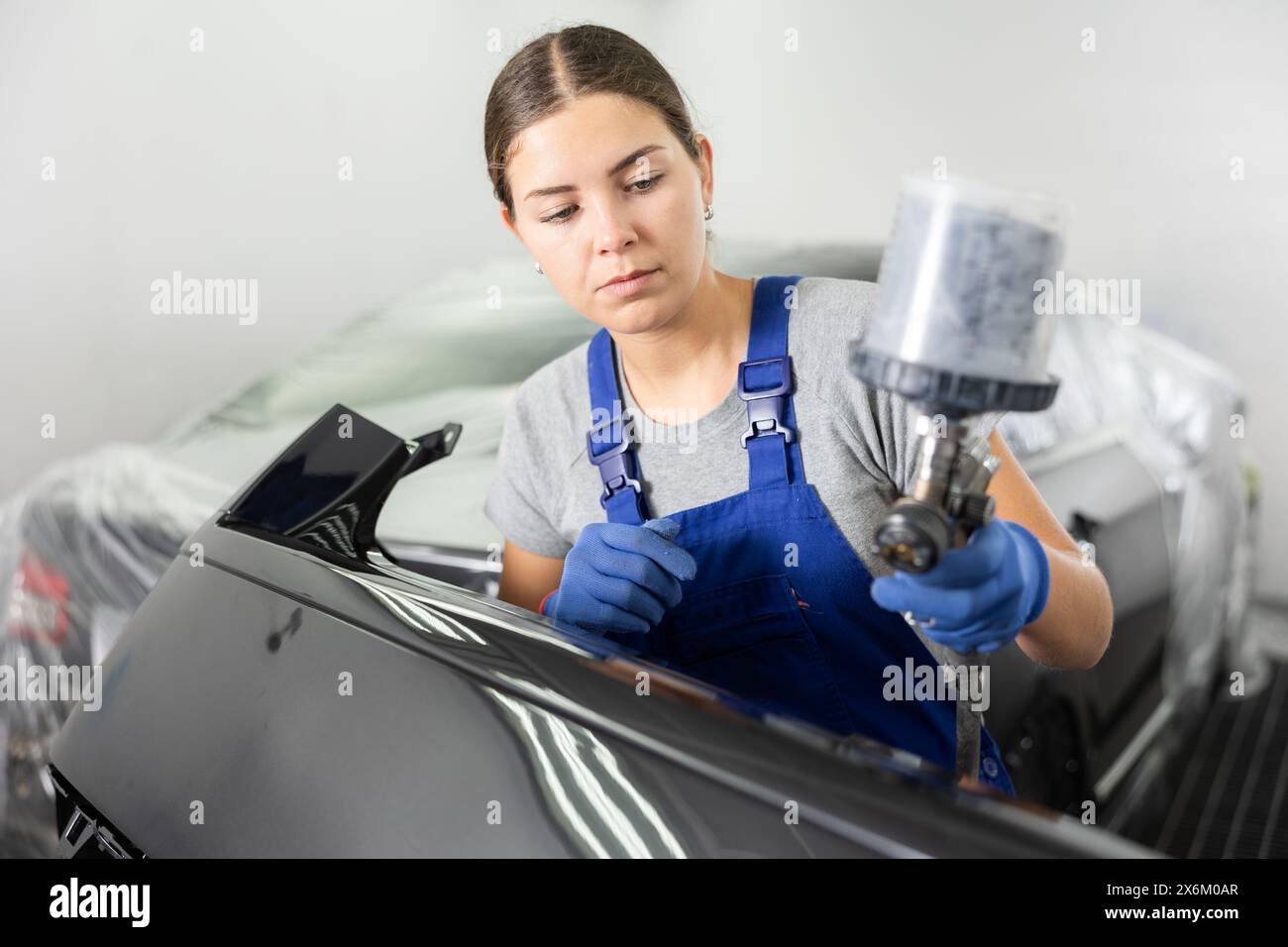 Young woman spray painting car hi-res stock photography and images - Alamy