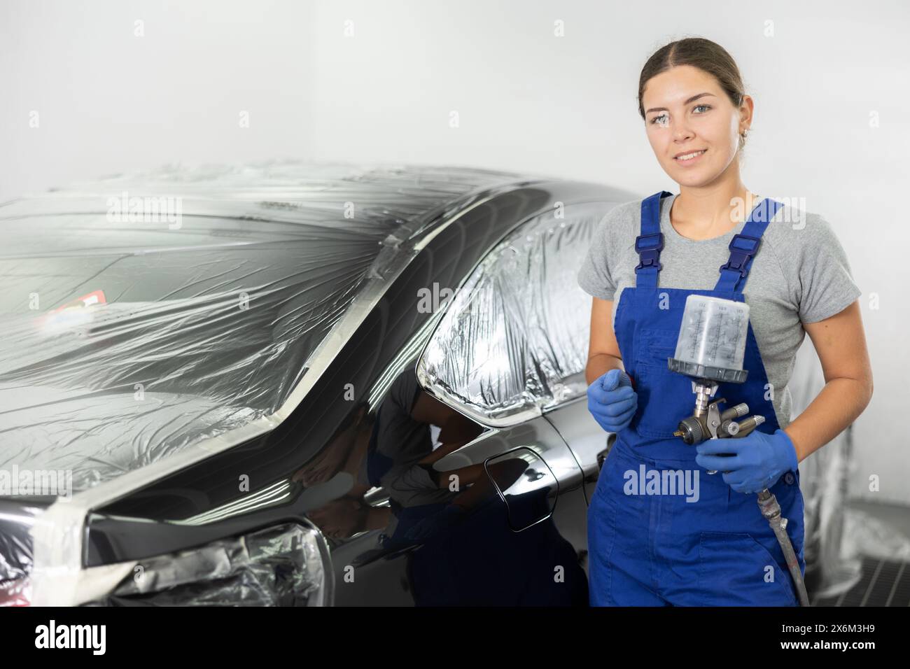 Young woman spray painting car hi-res stock photography and images - Alamy