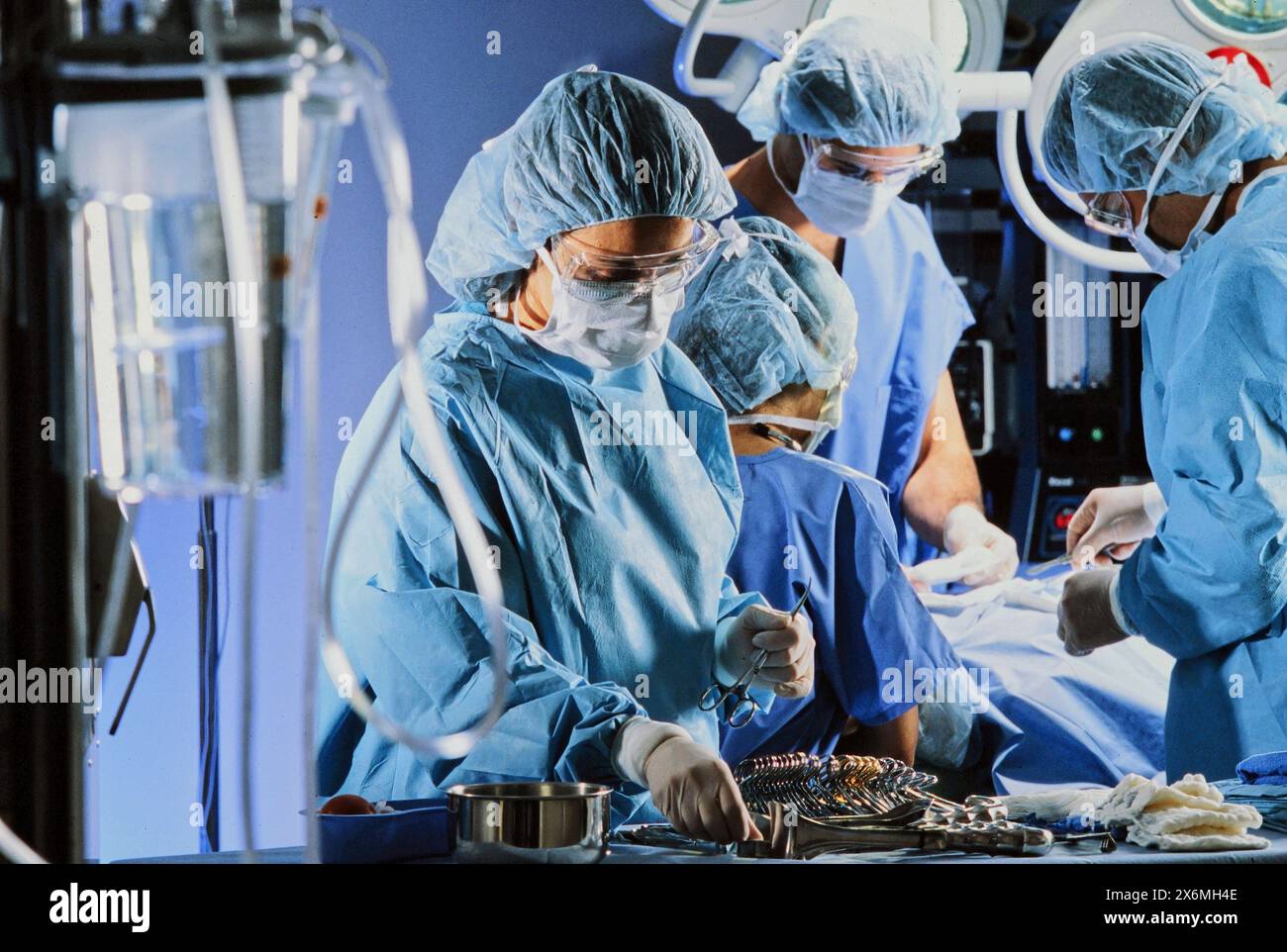 A group of highly skilled surgeons in scrubs and masks are working diligently in an operating room, performing a complex surgical procedure on a patie Stock Photo