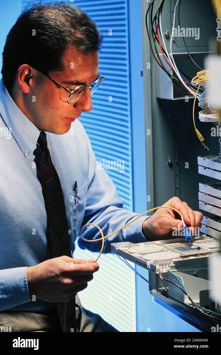 An Engineer is seen diligently focusing on diagnosing piece of equipment. He is surrounded by tools and machinery, showcasing his expertise and skill Stock Photo