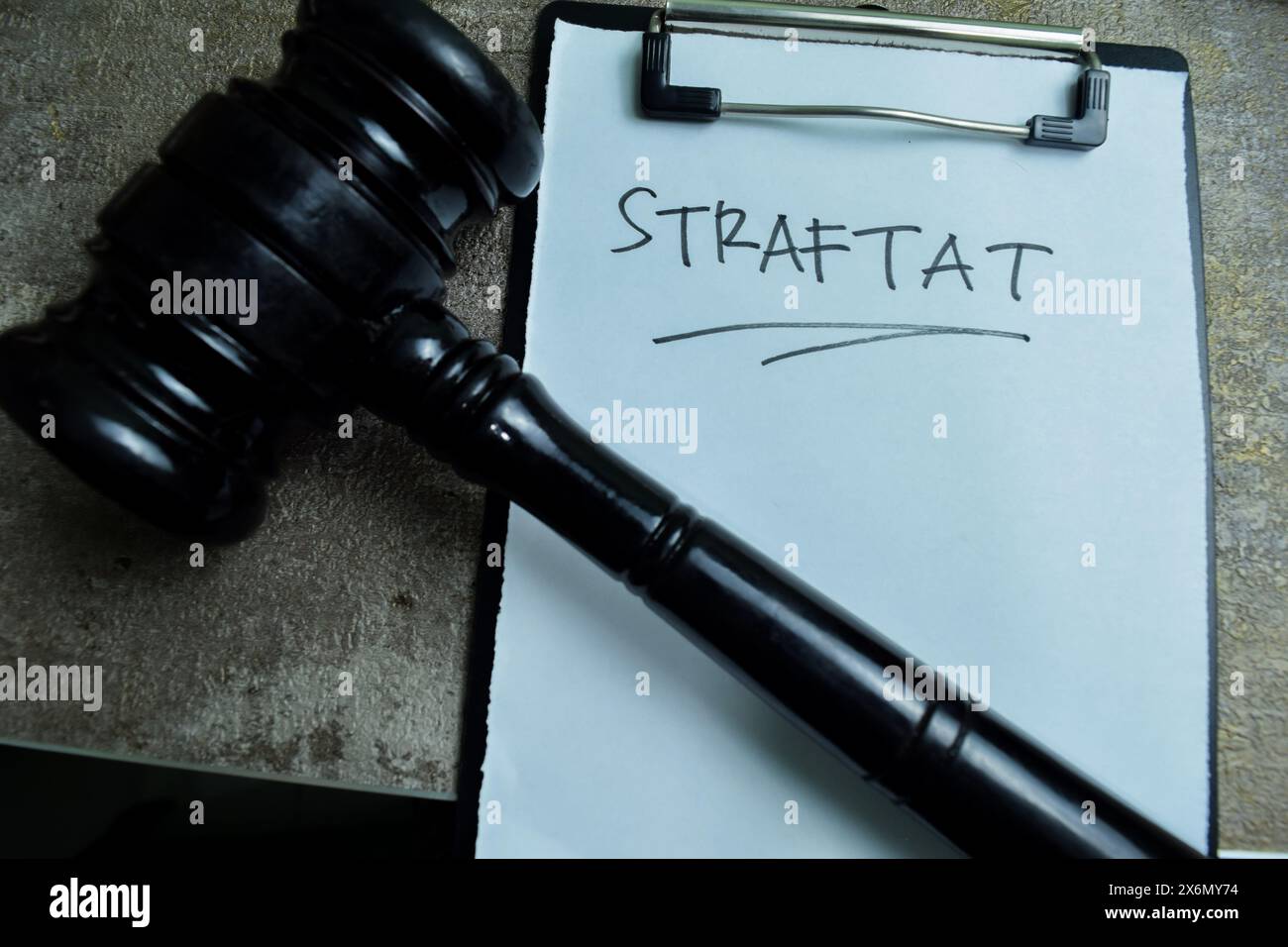 Concept of Learning language - German. Straftat it means crime written on paperwork. German language isolated on Wooden Table. Stock Photo