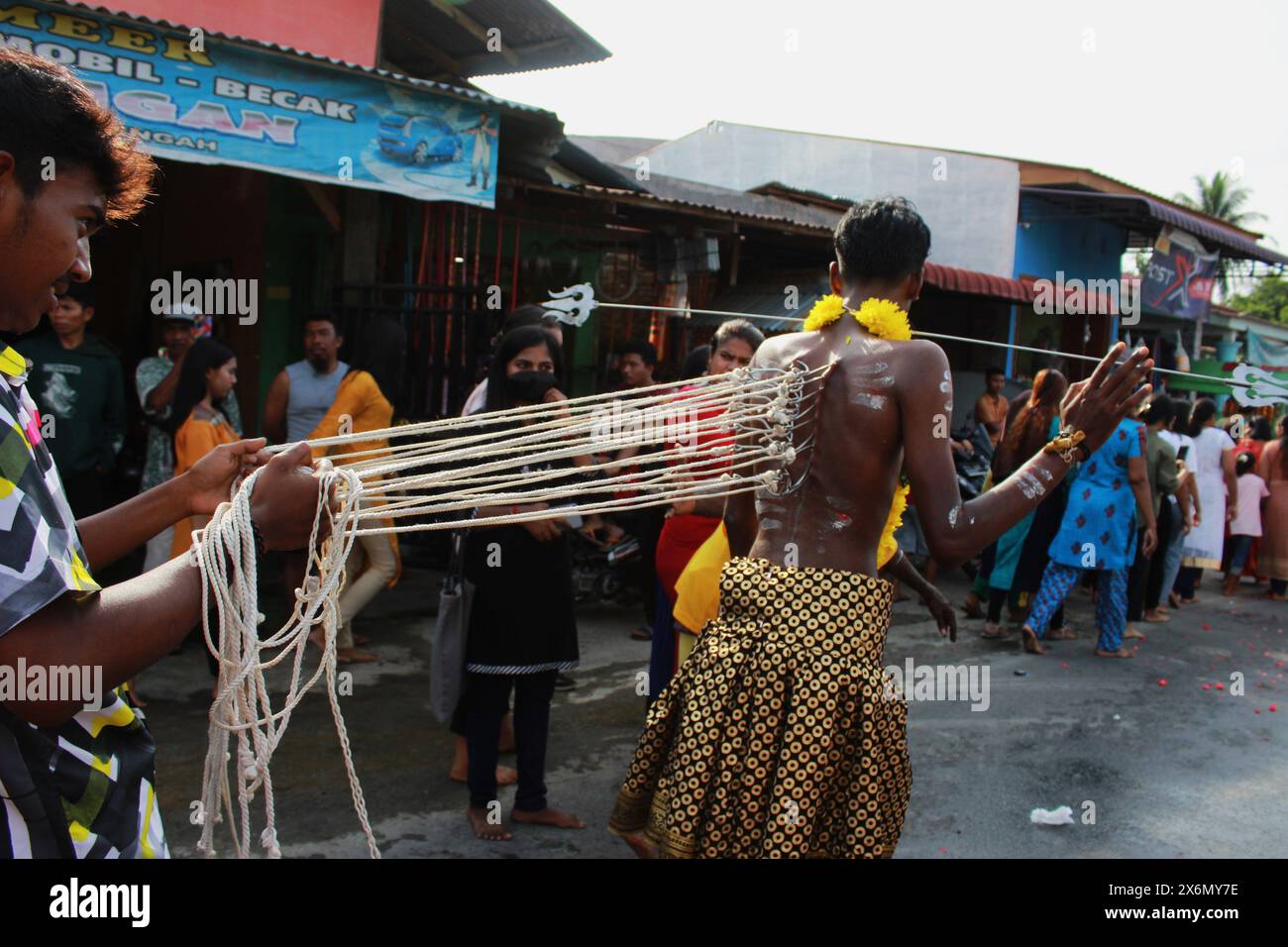 Medan, North Sumatra, Indonesia. 16th May, 2024. A boy, of India descent in Indonesia, is pulled using a metal hook in the shape of a gancu, while taking part in a hindu cultural body piercing ritual (Credit Image: © Kartik Byma/ZUMA Press Wire) EDITORIAL USAGE ONLY! Not for Commercial USAGE! Stock Photo