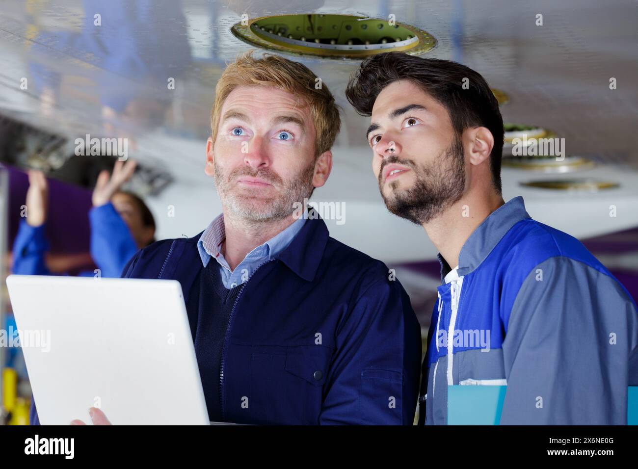 aero engineer and apprentice working in hangar Stock Photo