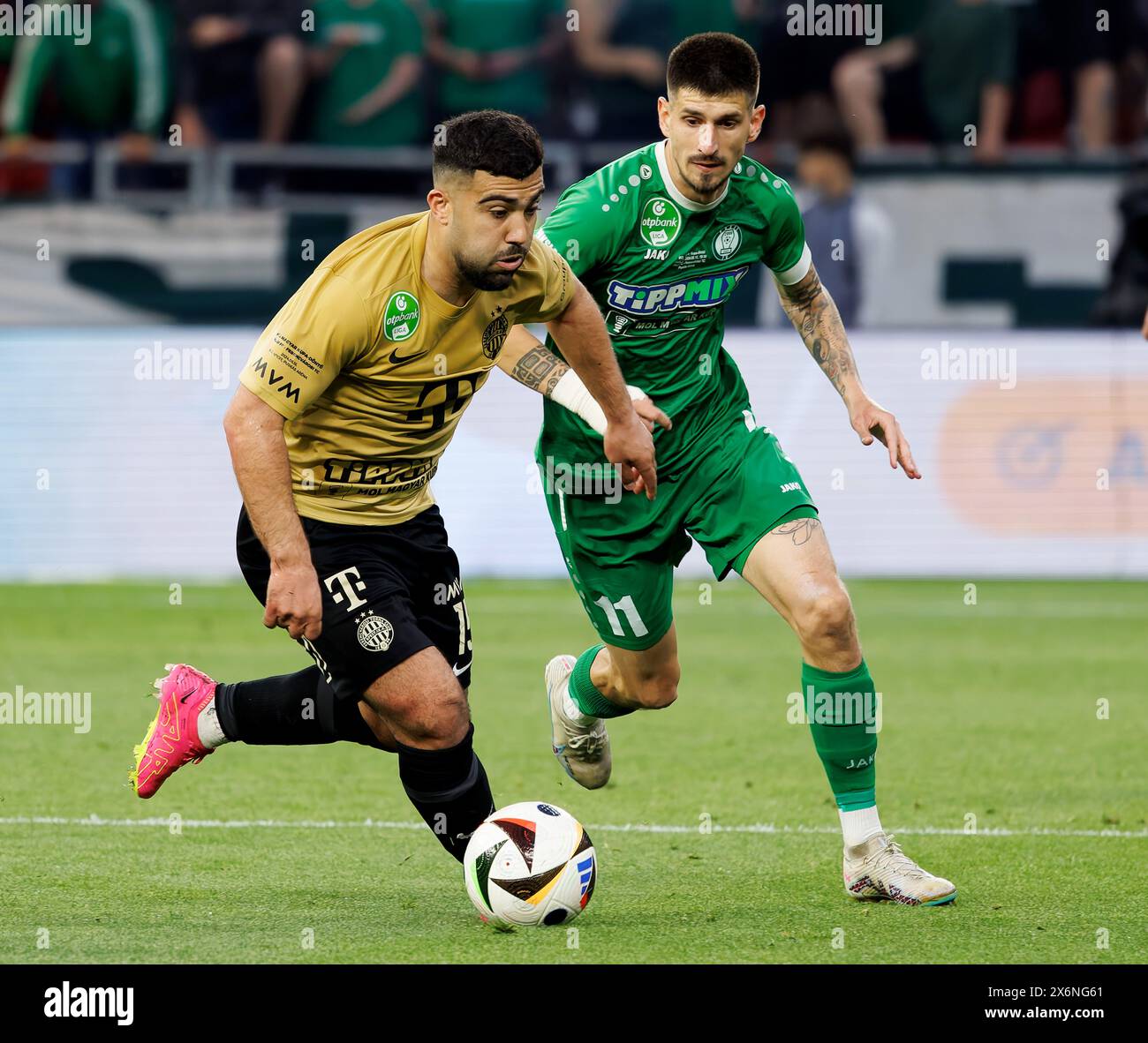 Budapest, Hungary. 15th May, 2024. Mohammad Abu Fani of Ferencvarosi TC competes for the ball with Attila Osvath of Paksi FC during the Hungarian Cup Final match between Paksi FC and Ferencvarosi TC at Puskas Arena on May 15, 2024 in Budapest, Hungary. Credit: Laszlo Szirtesi/Alamy Live News Stock Photo