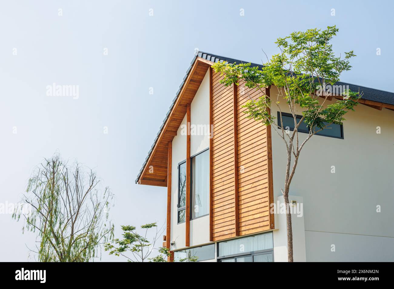green eco home wood material with garden green plant tree around the building, living with nature for saving energy cooling house Stock Photo