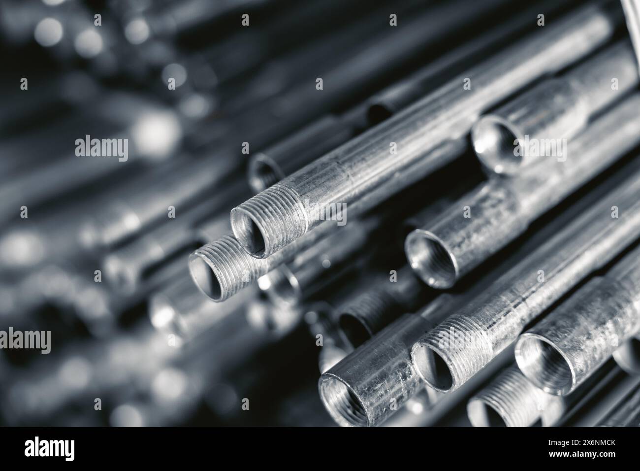 metal gas pipe store stack pile on shelf black and white vintage color tone. watering pump sewer