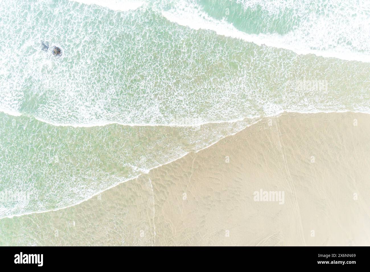 drone aerial overhead view of the foamy waves in a beach at low tide. Summer image, holidays concept Stock Photo