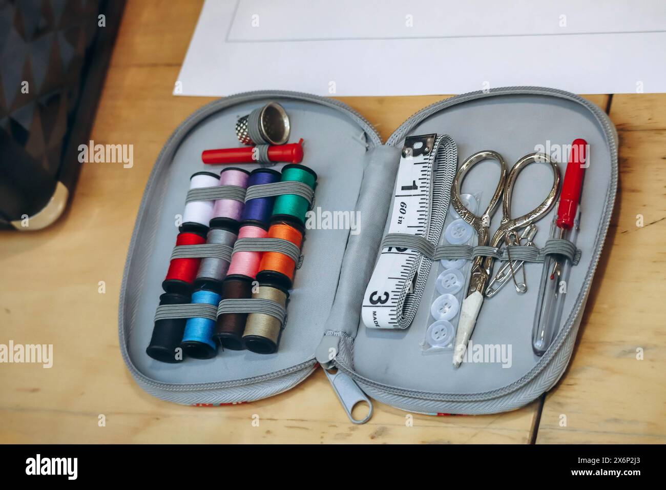Sewing kit including colored thread, scissors, measuring tape, pins and needles Stock Photo