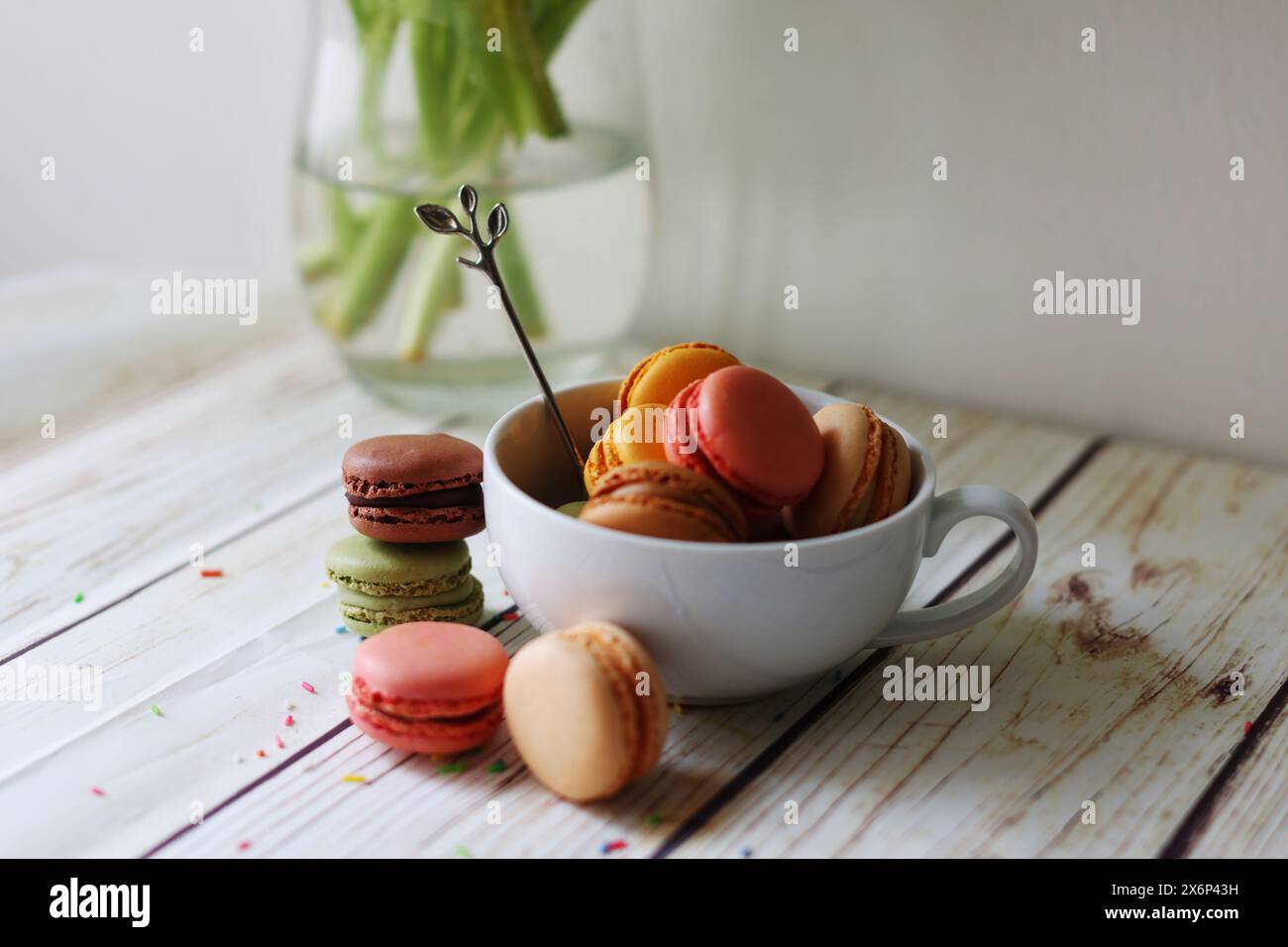 multi-colored macarons in a cup on the table Stock Photo