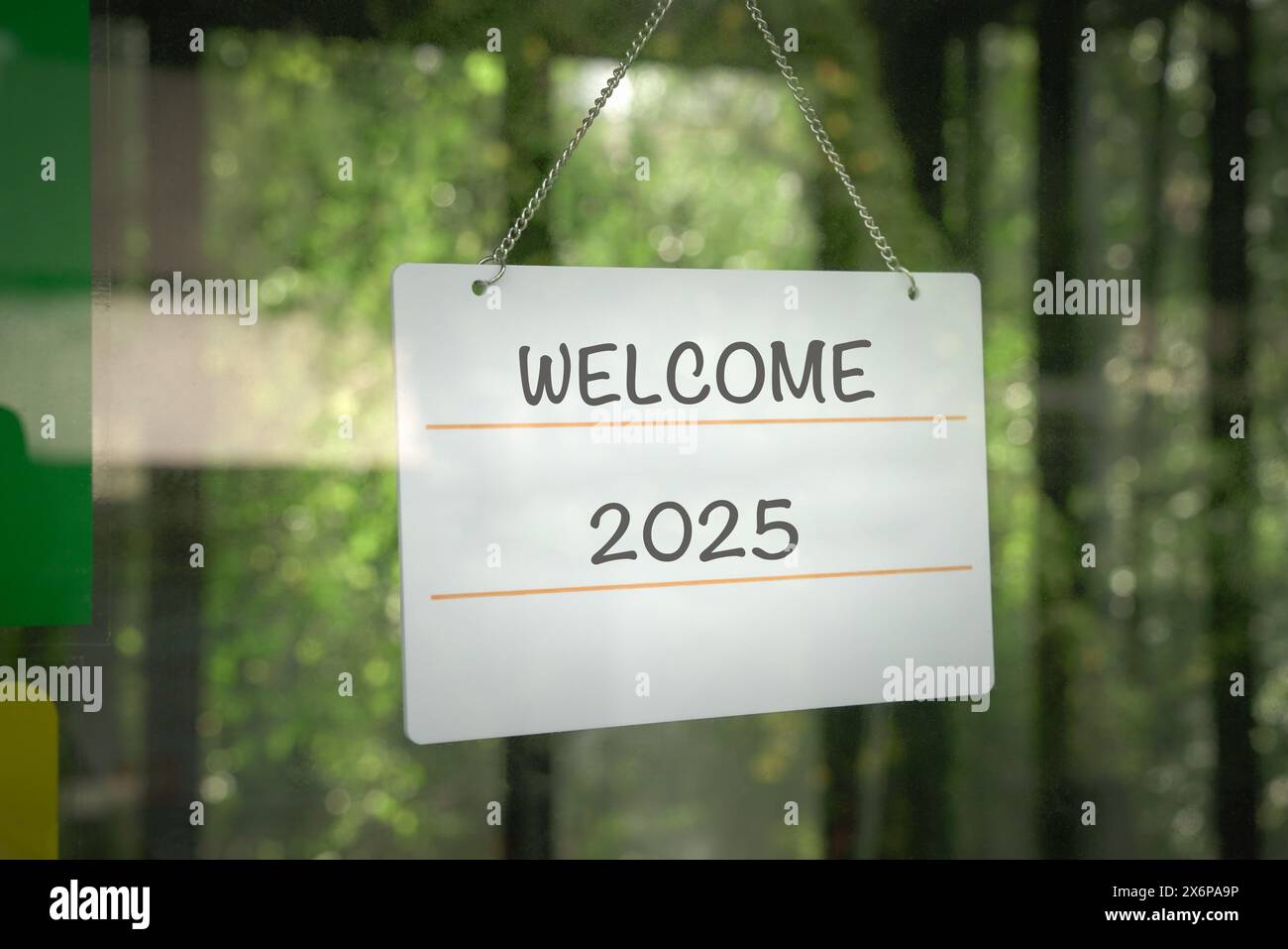 Welcome 2025 on a signboard, hanging on a glass door. Stock Photo