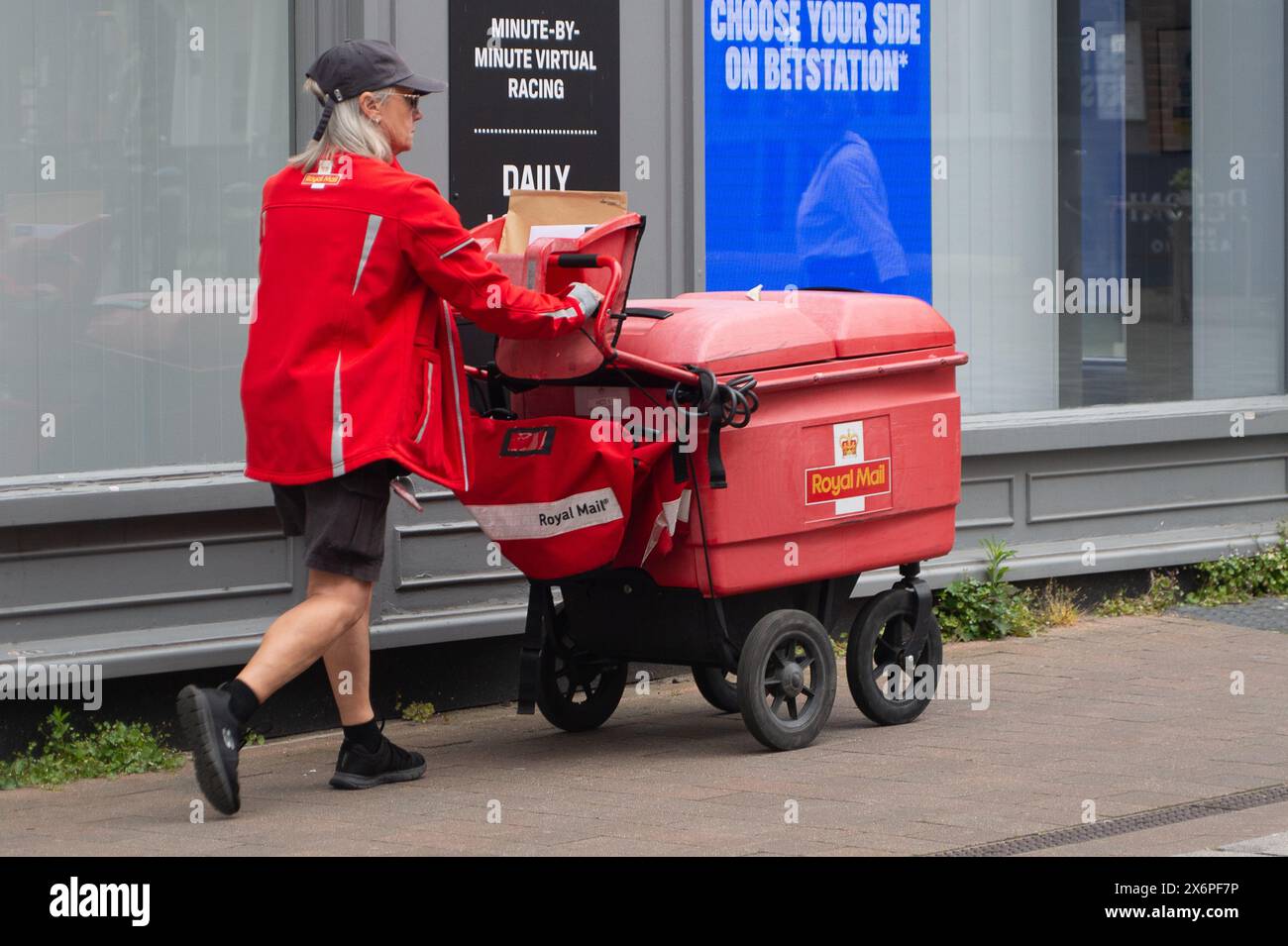 Windsor, Berkshire, UK. 16th May, 2024. A Royal Mail postal worker delivering mail in Windsor, Berkshire. The owner of Royal Mail are reportedly expected to accept a £3.5bn takeover bid from a Czech billionaire, Daniel Kretinsky. Royal Mail owners, International Distribution Services said it had received a revised proposal of 370p a share from Mr Kretinsky's EP Group. Credit: Maureen McLean/Alamy Live News Stock Photo