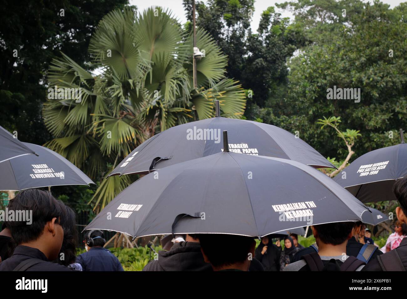 Participants of the Kamisan action using black umbrella during the 815th Kamisan rally Action in front of the preidential palace (Merdeka Palace) in Jakarta on Thursday (16/05/2024). The Indonesian government has never fully investigated cases of human rights violations in the past. Stock Photo