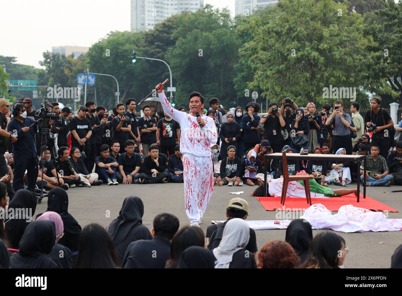 Students of Driyarkara School of Philosophy perform theatrical about the violence of indonesian police and military against students during the Kamisan Action in front of the preidential palace (Merdeka Palace) in Jakarta on Thursday (16/05/2024). Stock Photo