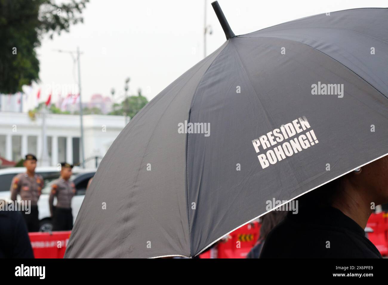 Participants of the Kamisan action with an umbrella with the inscription 'The president is a liar' during the 815th Kamisan rally Action in front of the preidential palace (Merdeka Palace) in Jakarta on Thursday (16/05/2024). The Indonesian government has never fully investigated cases of human rights violations in the past. Stock Photo