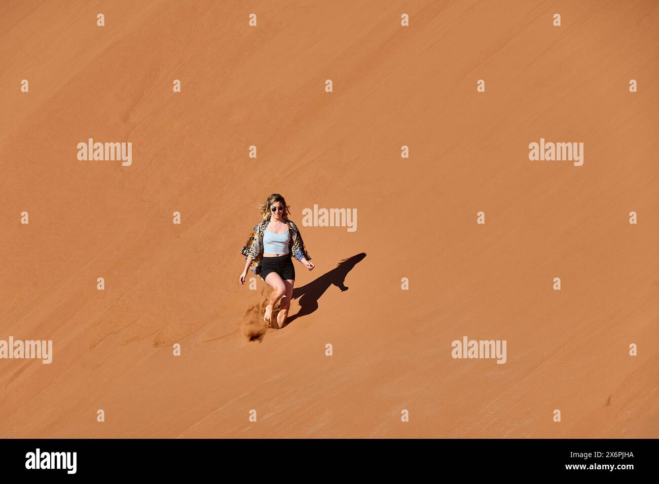 Young Woman Running Down A Sand Dune Stock Photo - Alamy