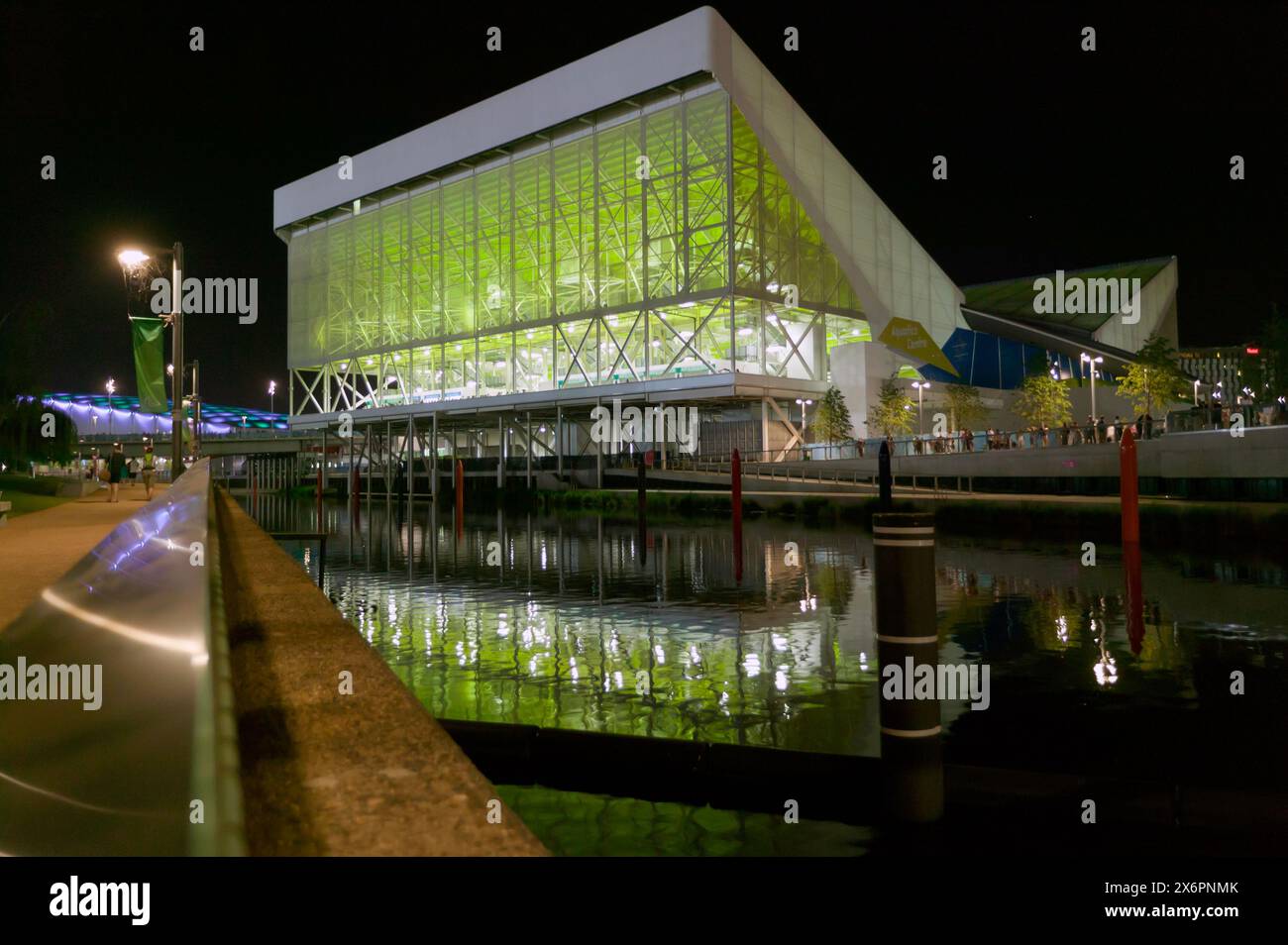 Night time image of the Aquatics Centre, reflected in the waters of the River Lea,  in the Queen Elizabeth II Olympic Park Stock Photo