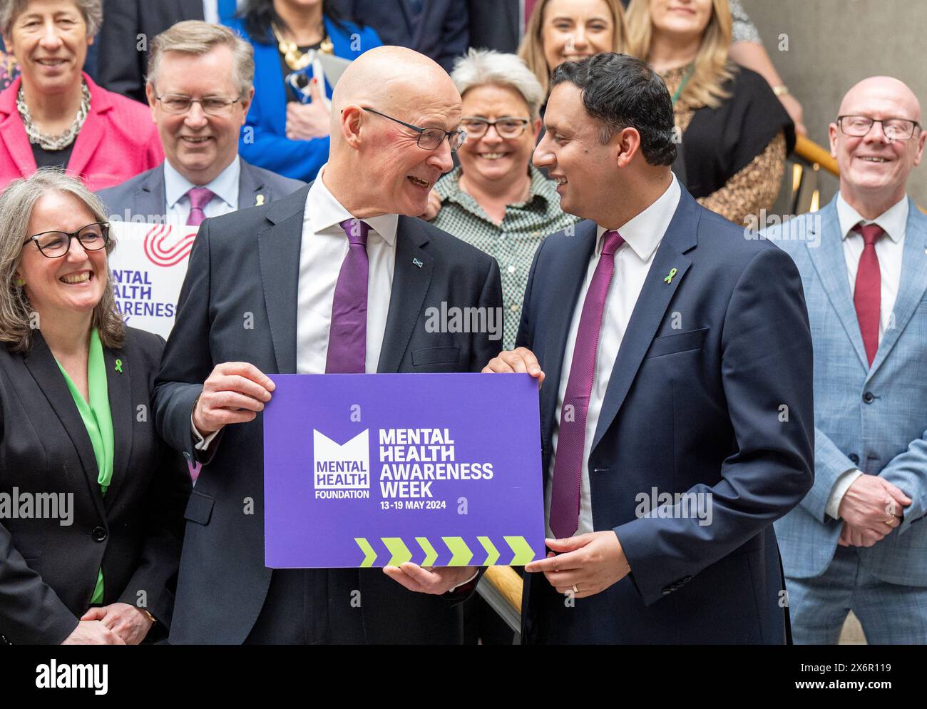 First Minister of Scotland John Swinney (left) and Scottish Labour leader Anas Sarwar (right) along with fellow MSPs show support for Mental Health Awareness Week 2024 in the Garden Lobby after First Minister's Questions at the Scottish Parliament in Holyrood, Edinburgh. Picture date: Thursday May 16, 2024. Stock Photo