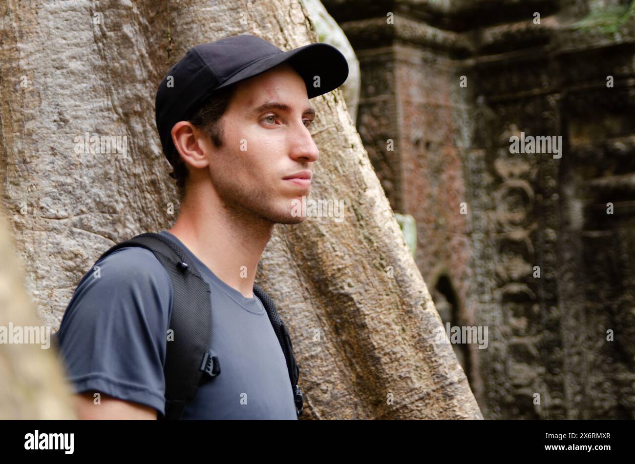 Caucasian Tourist in Front of The Big Trunk And Roots Of a Giant Tree in Ta Prohm, Angkor Wat, Siem Reap, Cambodia Stock Photo