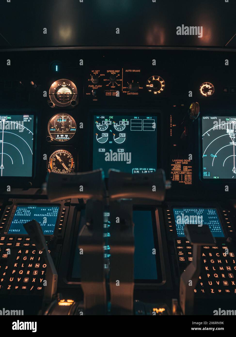 Cockpit view of an airplane during a nighttime flight with illuminated instrument panels Stock