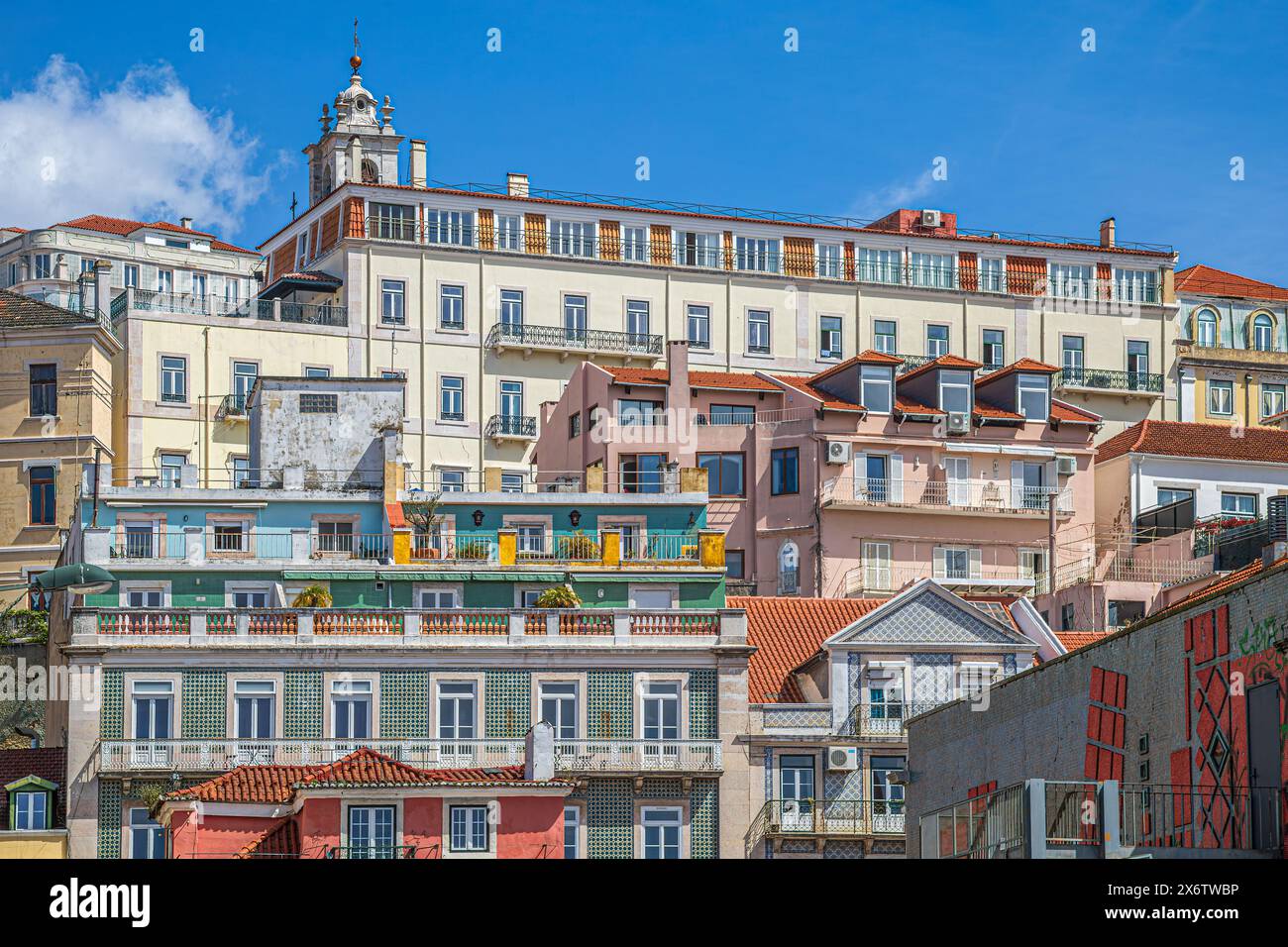 LISBON, PORTUGAL - APRIL 7, 2024: Panoramic view with old multicolored houses and traditional facades, placed in steps on a hill in the old town. Stock Photo