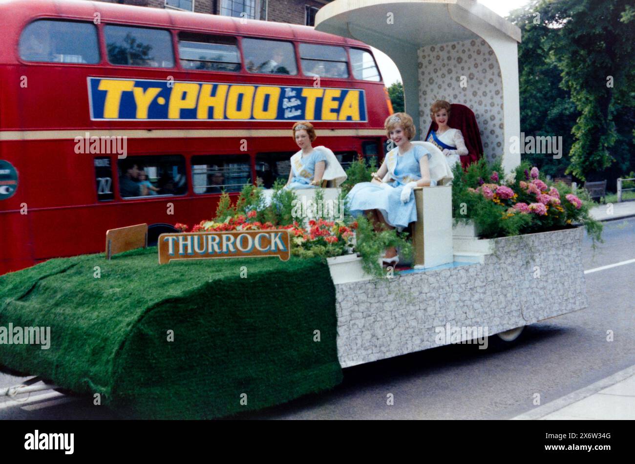 Thurrock Carnival Grand Parade 1963 passing through Grays, Essex, UK. Thurrock Carnival Queen Dawn Prior and Maids of Honour Ann Eveleigh and Irene McKenna on floral float. Traditional English local community event. Stock Photo