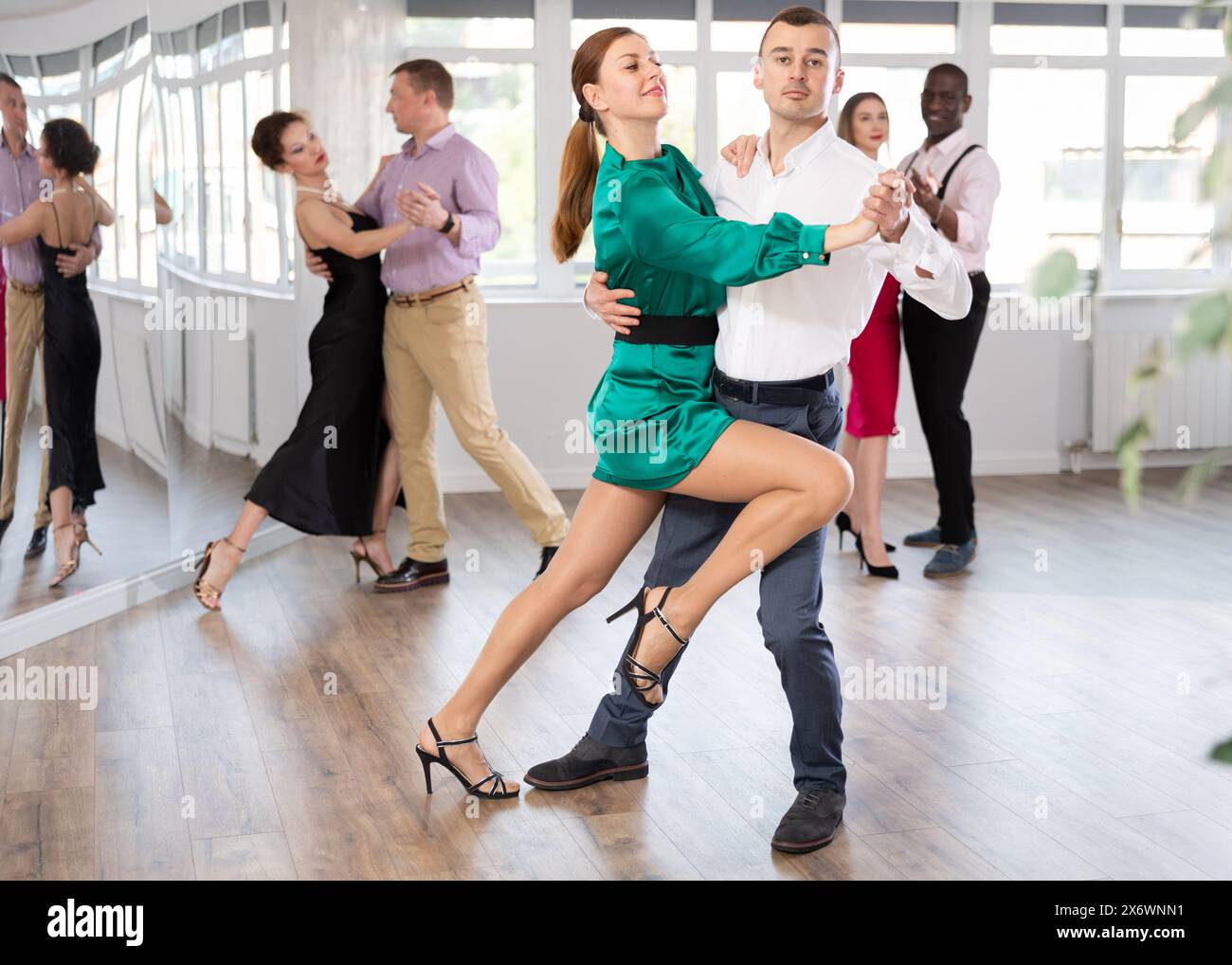Elegant couple performs an expressive tango in bright, modern dance ...
