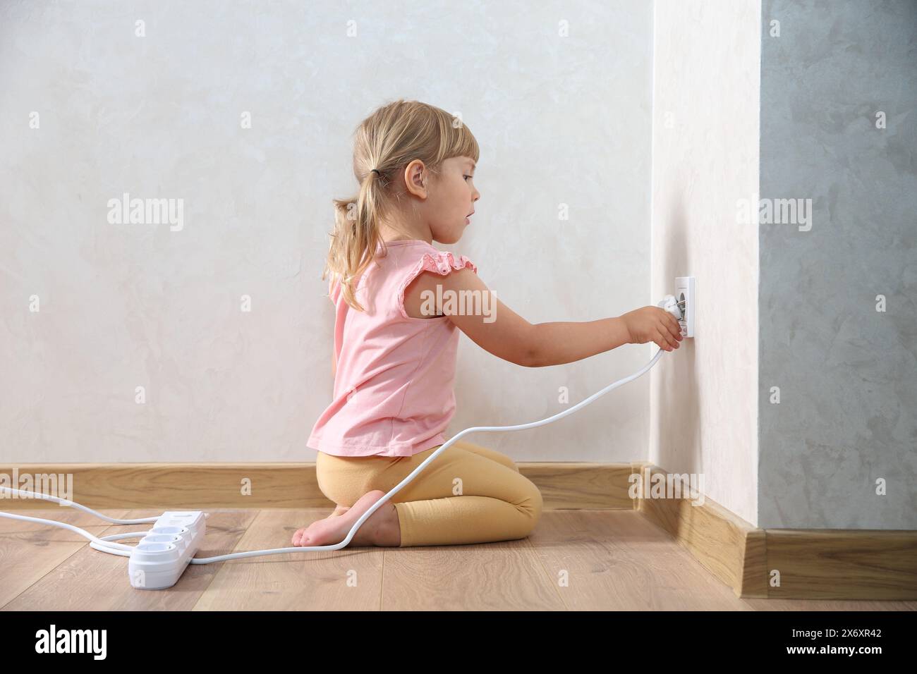 Little child playing with electrical socket and power strip plug at ...