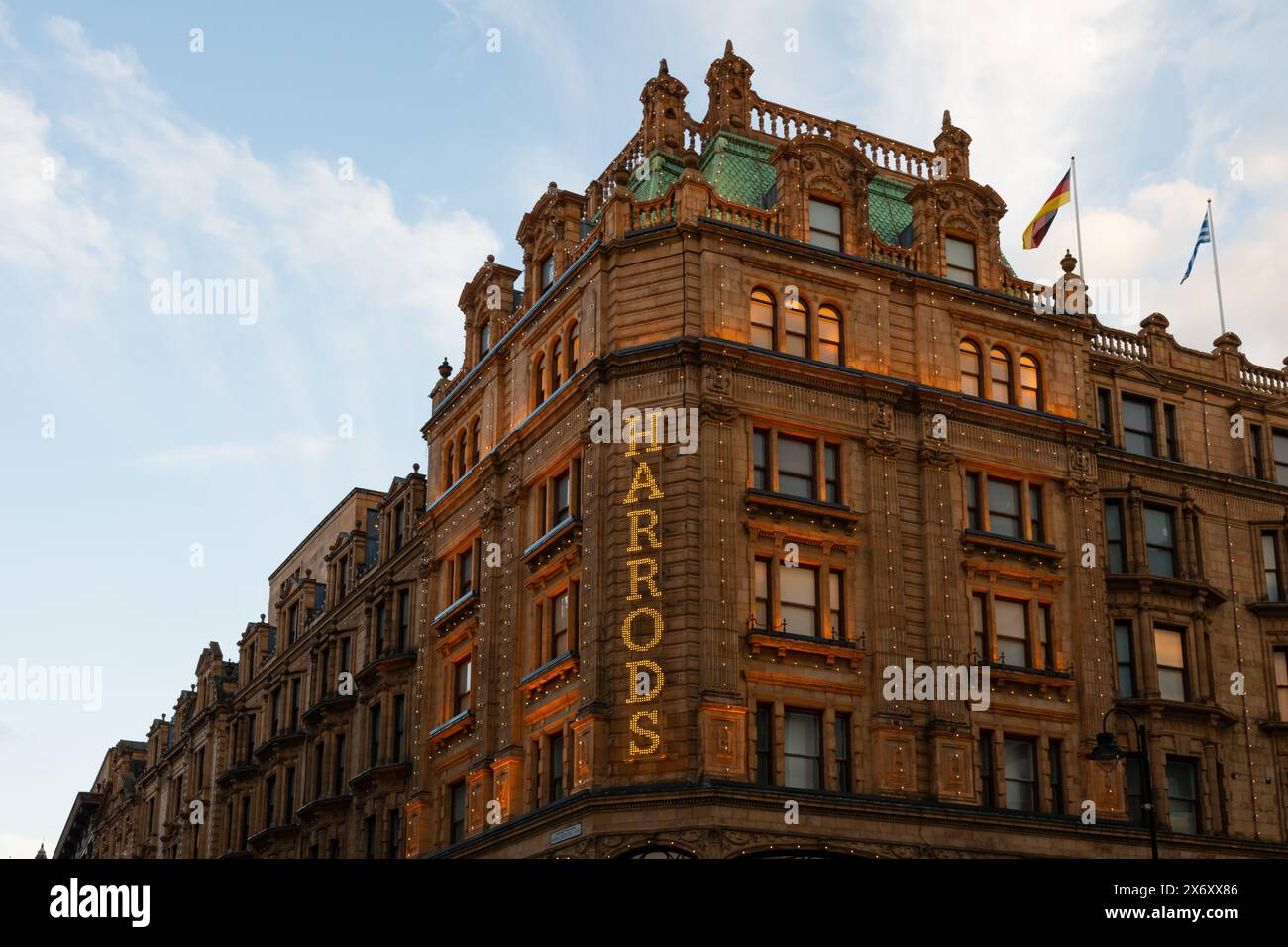 London, UK - March 22, 2024; Detail of Harrods department store sign illuminated on facade  in evening light Stock Photo