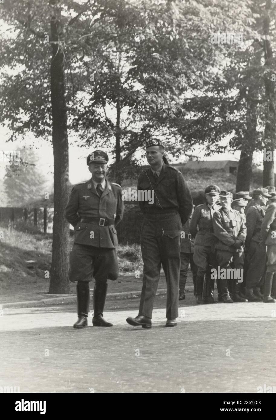 German prisoners of war, German prisoners of war guarded by English? soldiers. On the left, a senior Luftwaffe officer, next to him an Allied soldier. Prisoners of war in the background., photograph, anonymous, Netherlands, May-1945, photographic support, height, 13 cm × width, 17.5 cm Stock Photo