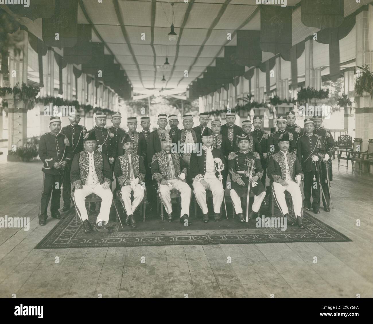 Group portrait of high-ranking officials at the court of Langkat, First row: Toengkoe Zainal Abidin of Pangkalan Brandan, Toenkoe Adil of Bindjei, Sultan of Langkat, Assistant Resident Roos van Raadshoven, Mahmoed, son of sultan and Djaksa (procurator general) of Tanjongpoera, second row : Dato of Besitan and unknown Dato's. This photo is part of an album., photograph, anonymous, 1919, photographic support, gelatin silver print, height, 220 mm × width, 270 mm Stock Photo
