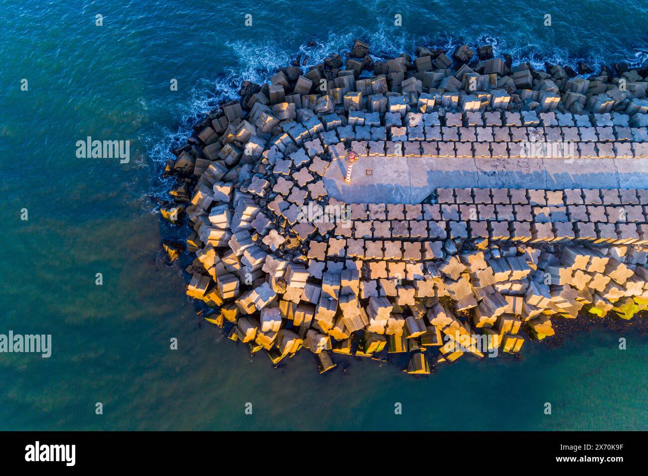 drone aerial overhead view of a port harbor breakwater at sunset Stock Photo