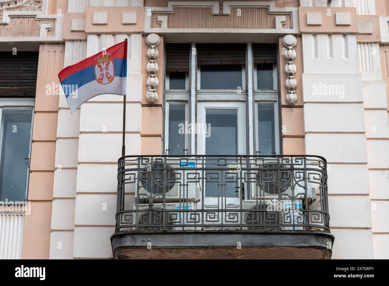 Serbian national flag flying outside of a balcony in the city of Novi Sad. April 2024. Stock Photo