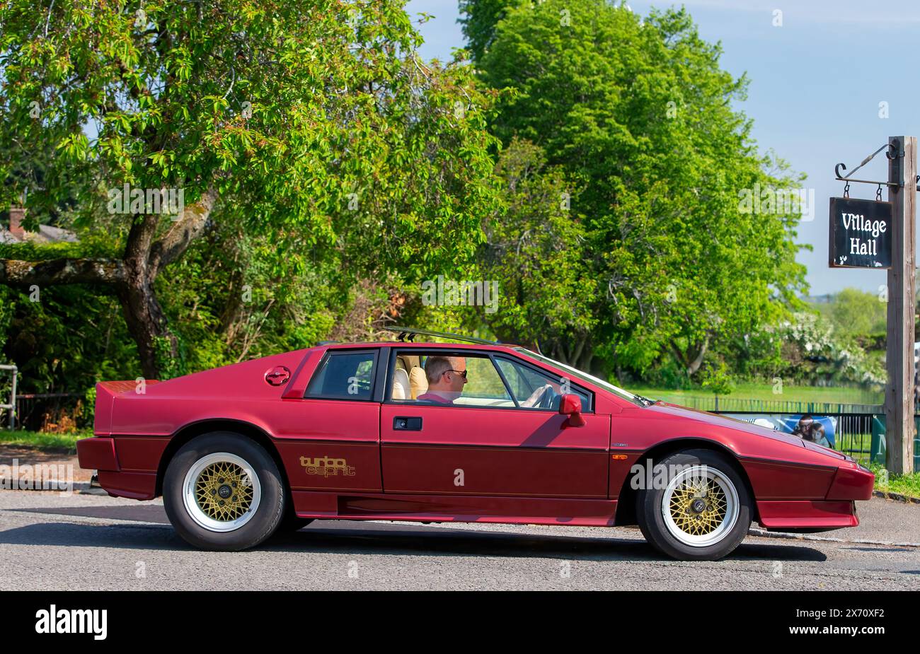 Stoke Goldington,UK - May 11th 2024: 1986 maroon Lotus Esprit classic car travelling through an English village Stock Photo