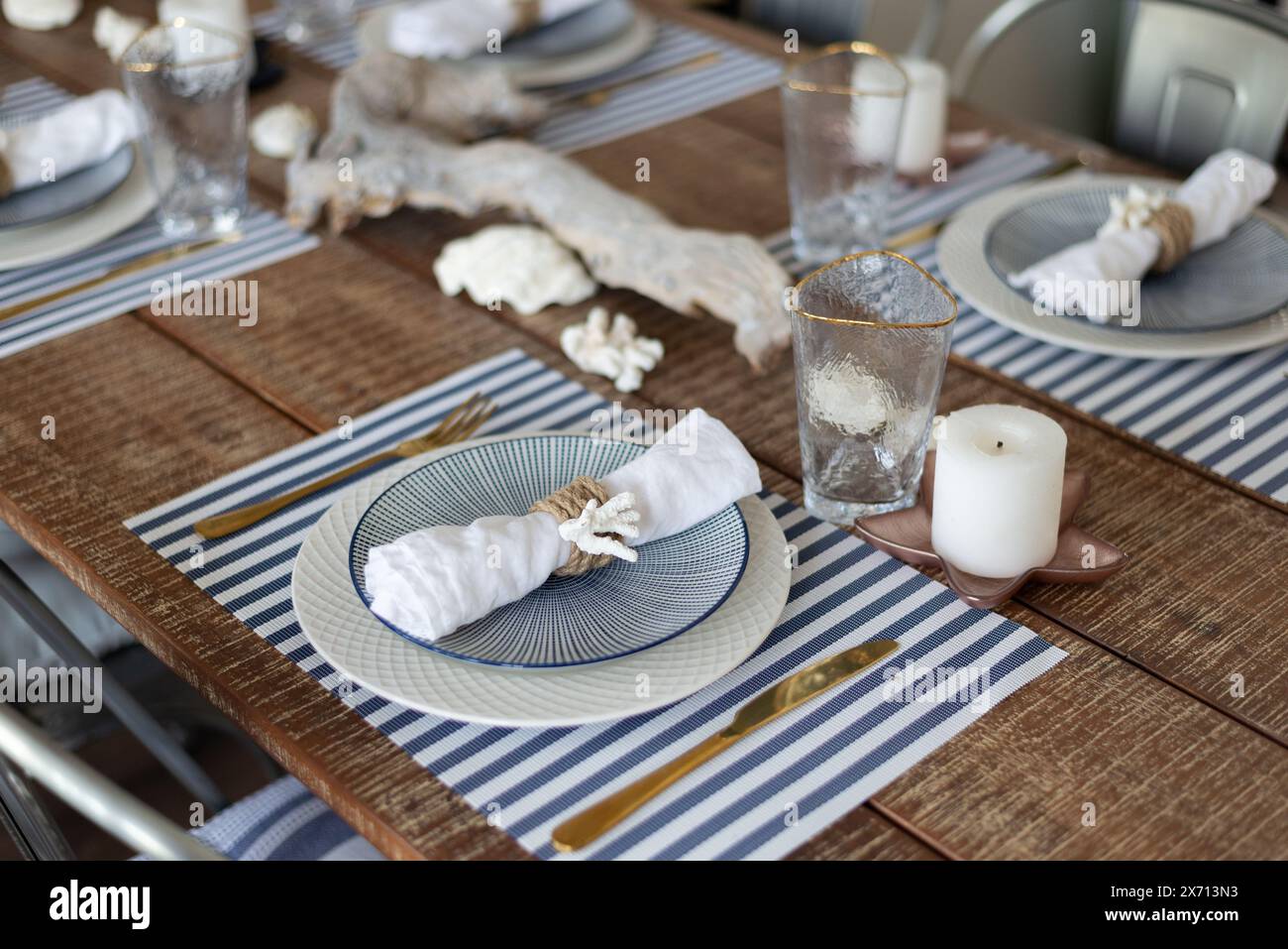 A silver-out table. plates and appliances in a wooden style. tree branch. table, chairs. Stock Photo