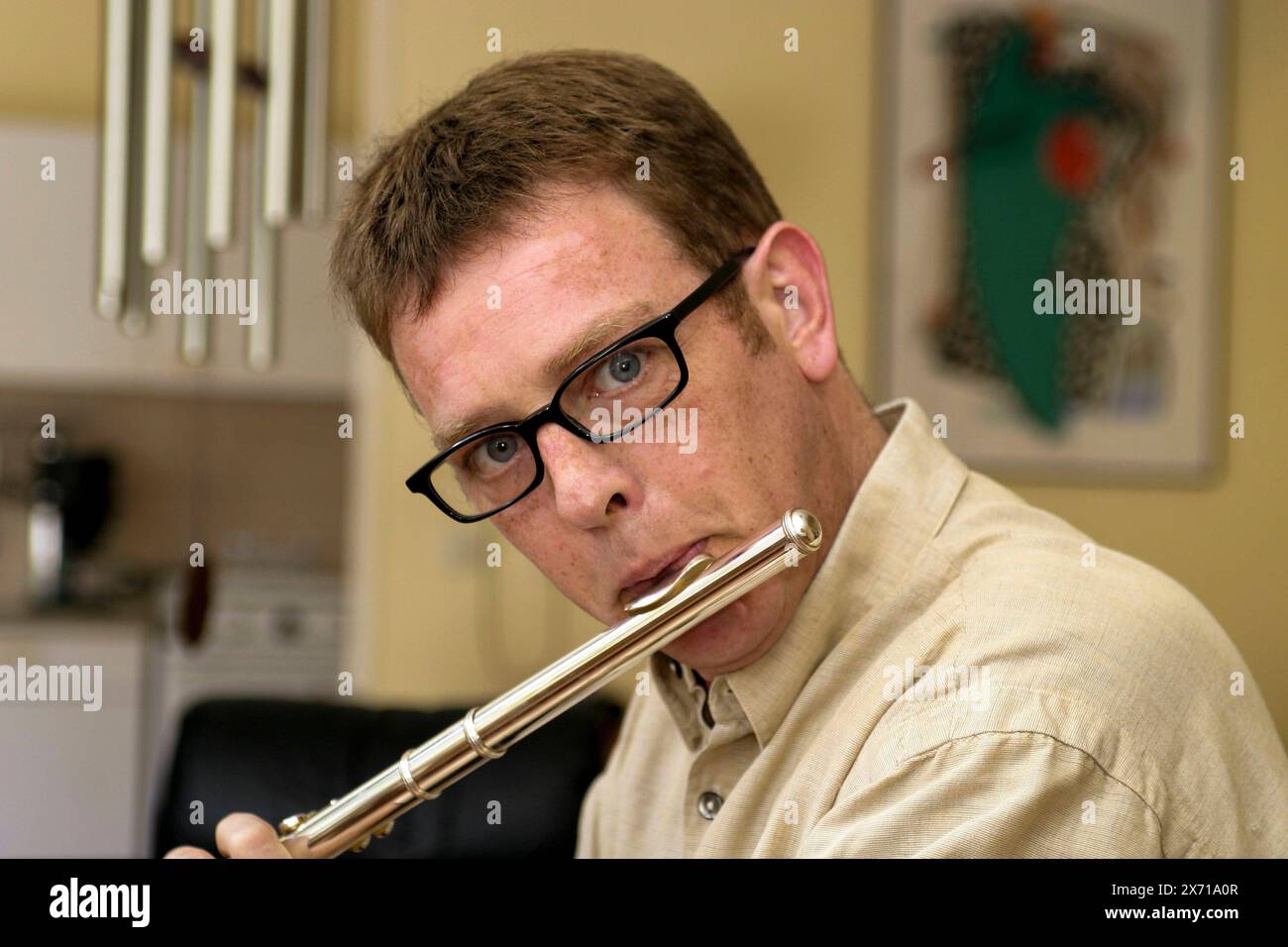 Man playing the Flute Portrait of a 39 year old male wearing glasses and playing the flute. This music instrument is usually associaled with women. By SRC. Tilburg, Netherlands. MRYES Tilburg Studio Tuinstraat Noord-Brabant Nederland Copyright: xGuidoxKoppesxPhotox Stock Photo