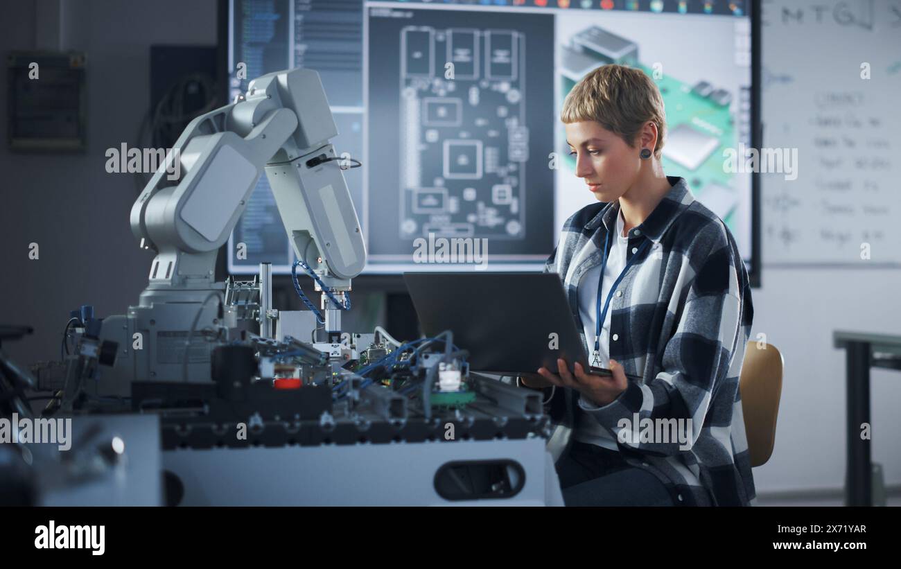 Caucasian Developer Writing Code at Laptop while Working with Robotic Arm. Startup and Programming at Laboratory. High-Tech Science, Robotics and Research at University of Technology Concept. Stock Photo