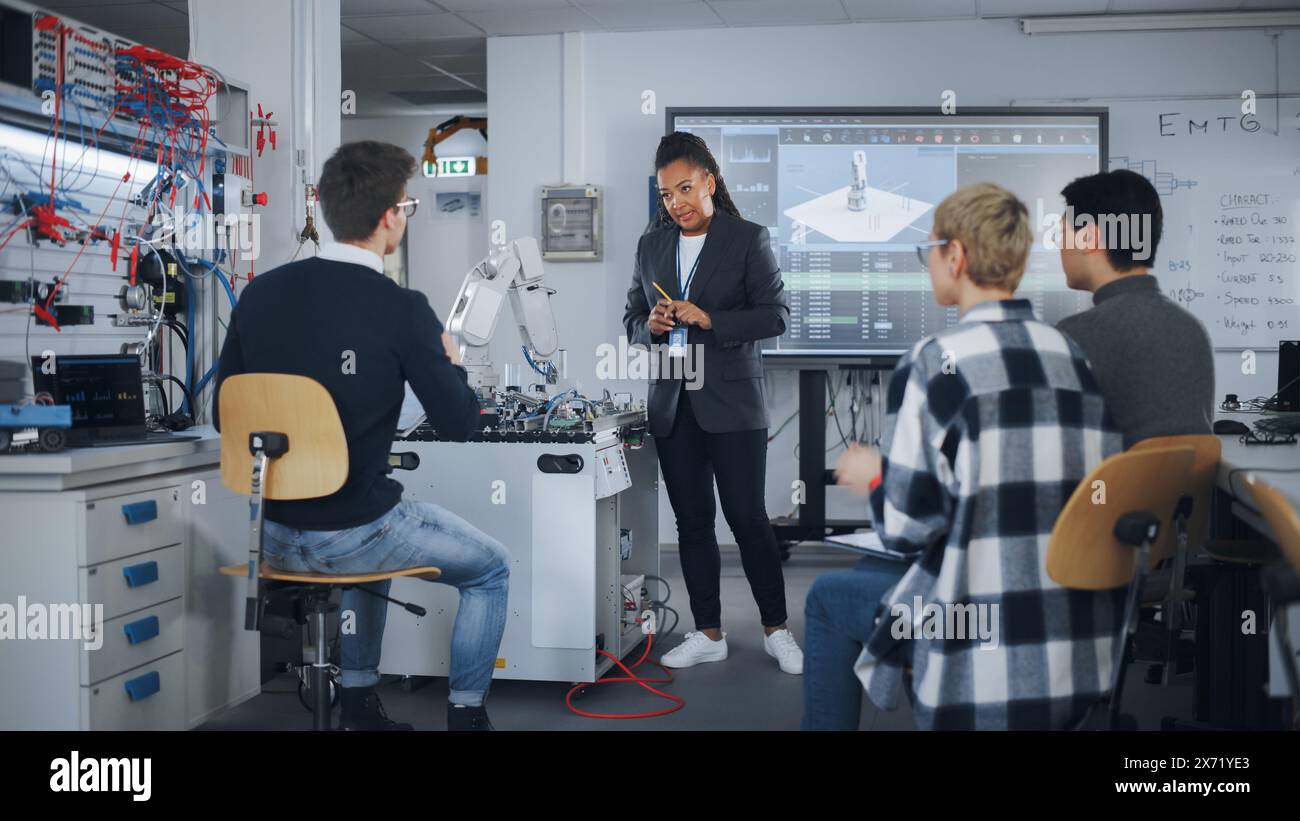 Teacher is Explaining Principles of Working With Robotic Hand, Showing Examples on Big Screen at Modern University. Teenagers Brainstorming and Asking Questions. Robotic Engineering Concept. Stock Photo