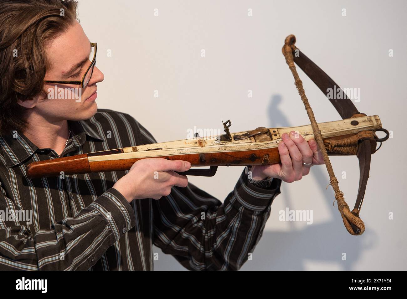 London, England, UK. 17th May, 2024. Bonhams staff member holds a German sporting crossbow, late 16th century, estimated at Â£800 - Â£1,200, during an Antique Arms and Armour sale preview at Bonhams Knightsbridge. (Credit Image: © Thomas Krych/ZUMA Press Wire) EDITORIAL USAGE ONLY! Not for Commercial USAGE! Stock Photo