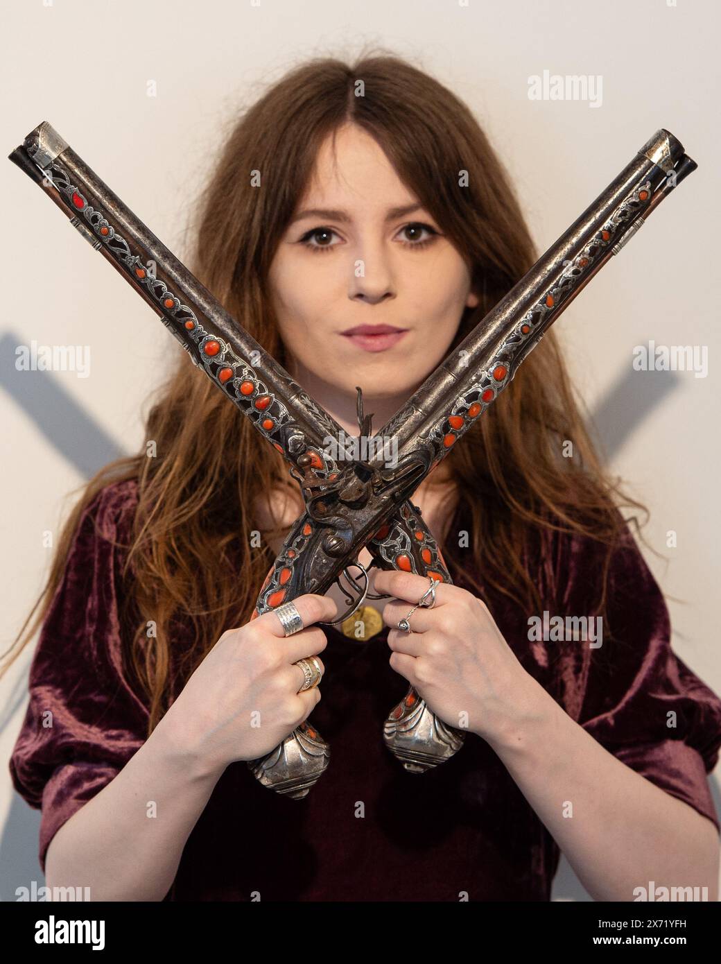 London, England, UK. 17th May, 2024. Bonhams staff member holds a pair of rare Algerian 18-bore flintlock holster pistols, dated late 18th/early 19th century, estimated at Â£5,000 - Â£6,000, during an Antique Arms and Armour sale preview at Bonhams Knightsbridge. (Credit Image: © Thomas Krych/ZUMA Press Wire) EDITORIAL USAGE ONLY! Not for Commercial USAGE! Stock Photo