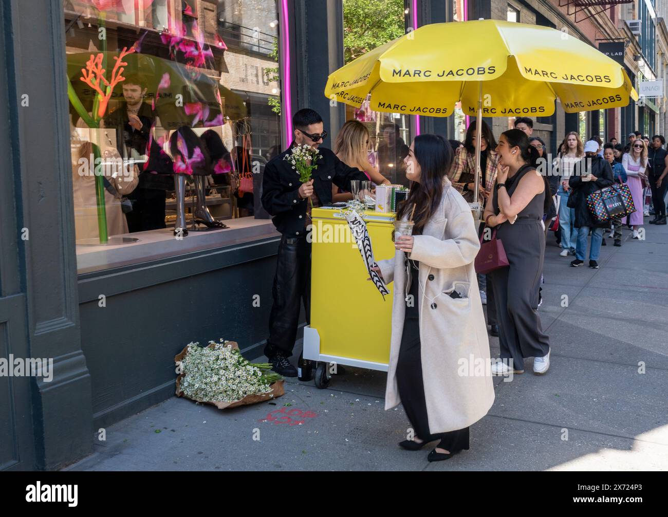 Shoppers at the Marc Jacobs store in Soho in New York line up to receive bouquets of daisies for Mother’s Day, on Saturday, May 11, 2024. Daisy the name of Jacobs’ line of fragrance. (© Richard B. Levine) Stock Photo