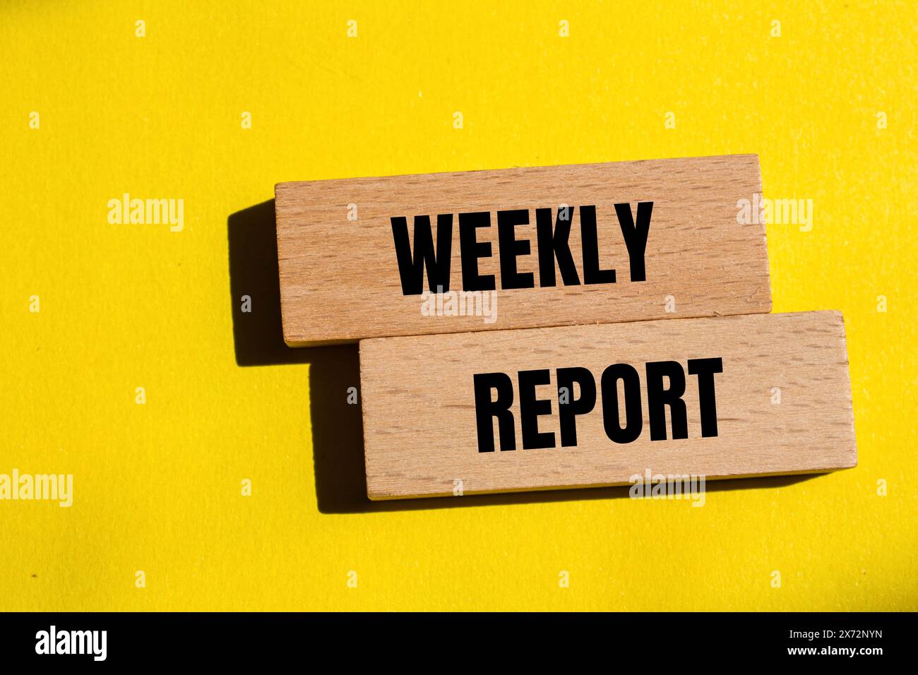 Weekly report words written on wooden blocks with yellow background ...