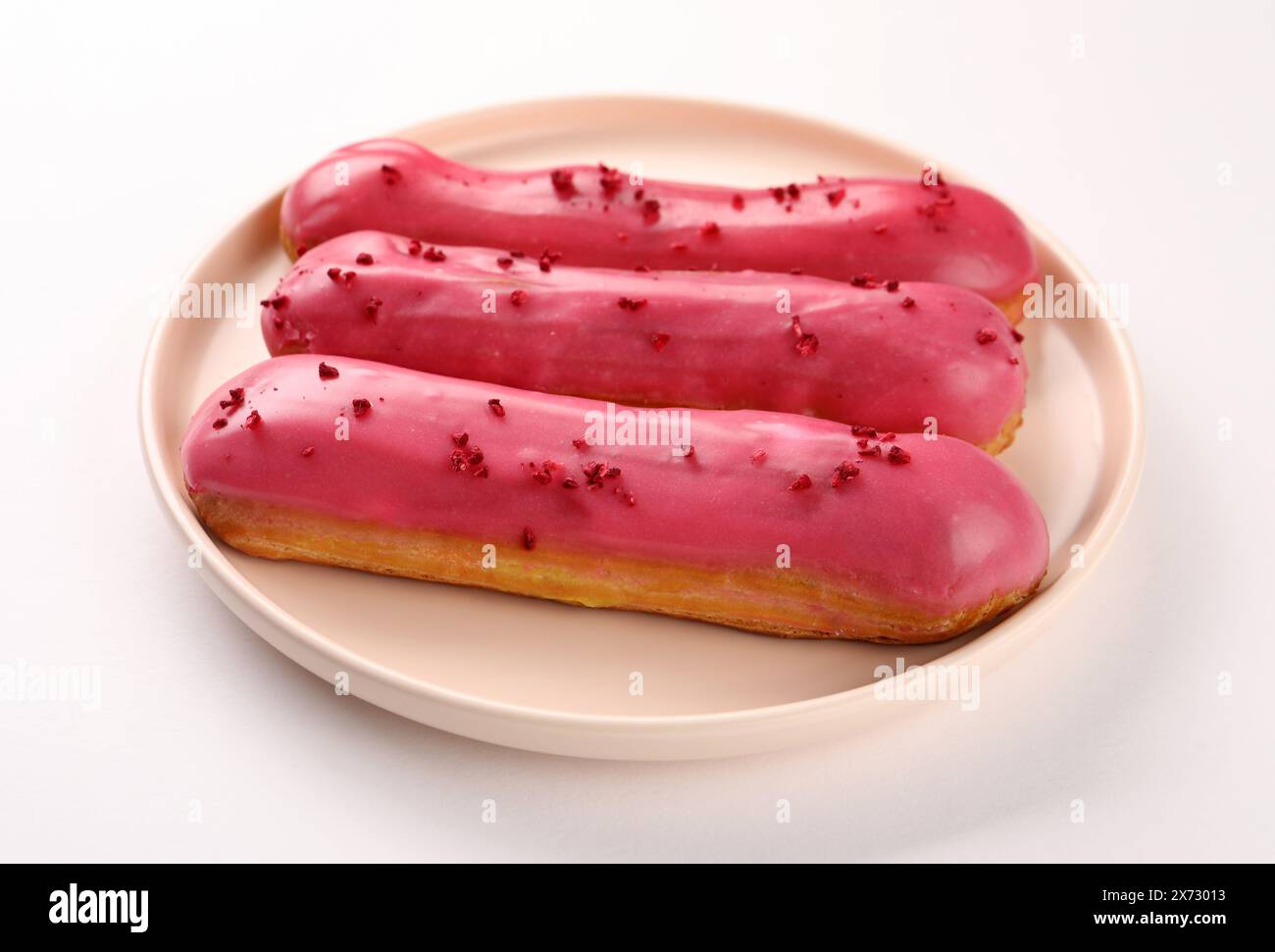 Delicious eclairs covered with glaze on white background, Stock Photo