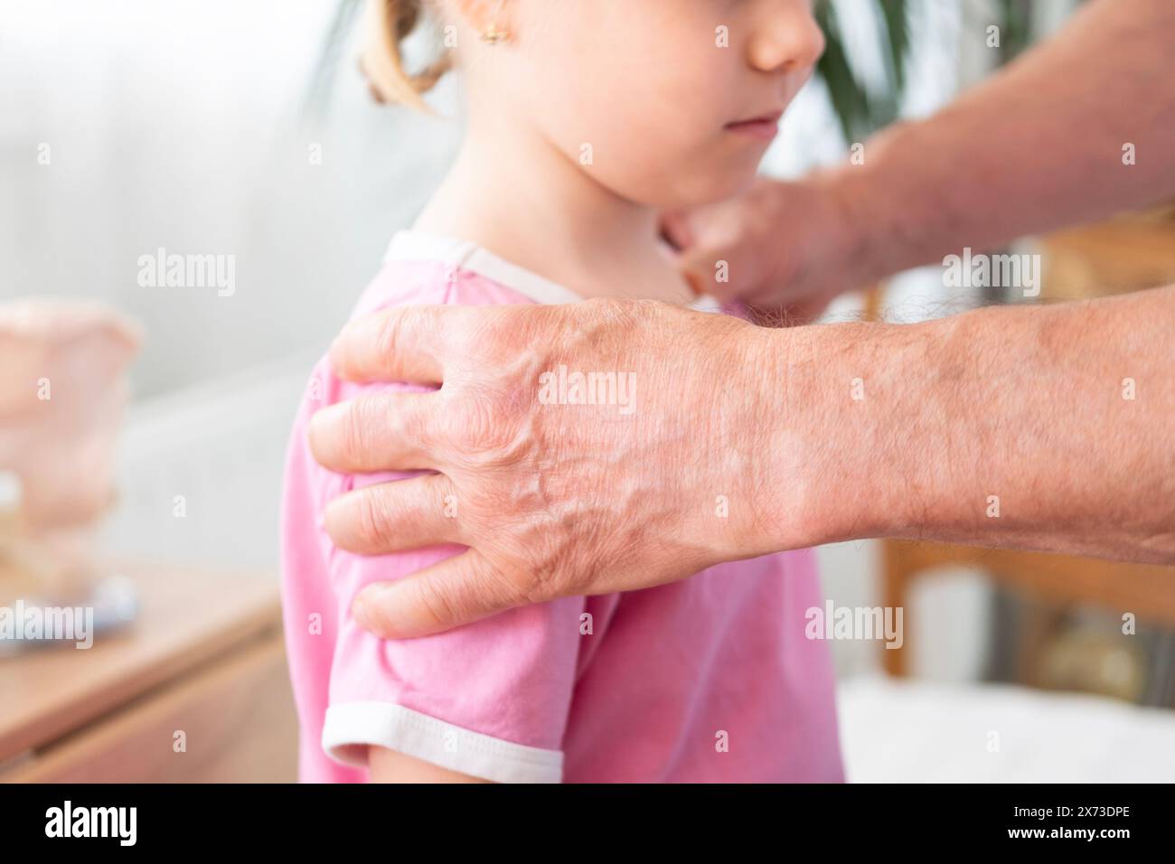 male Orthopedist doctor conducts spinal examination child, young girl shows signs scoliosis, spine deformity, healthcare provider, spine inspection, h Stock Photo