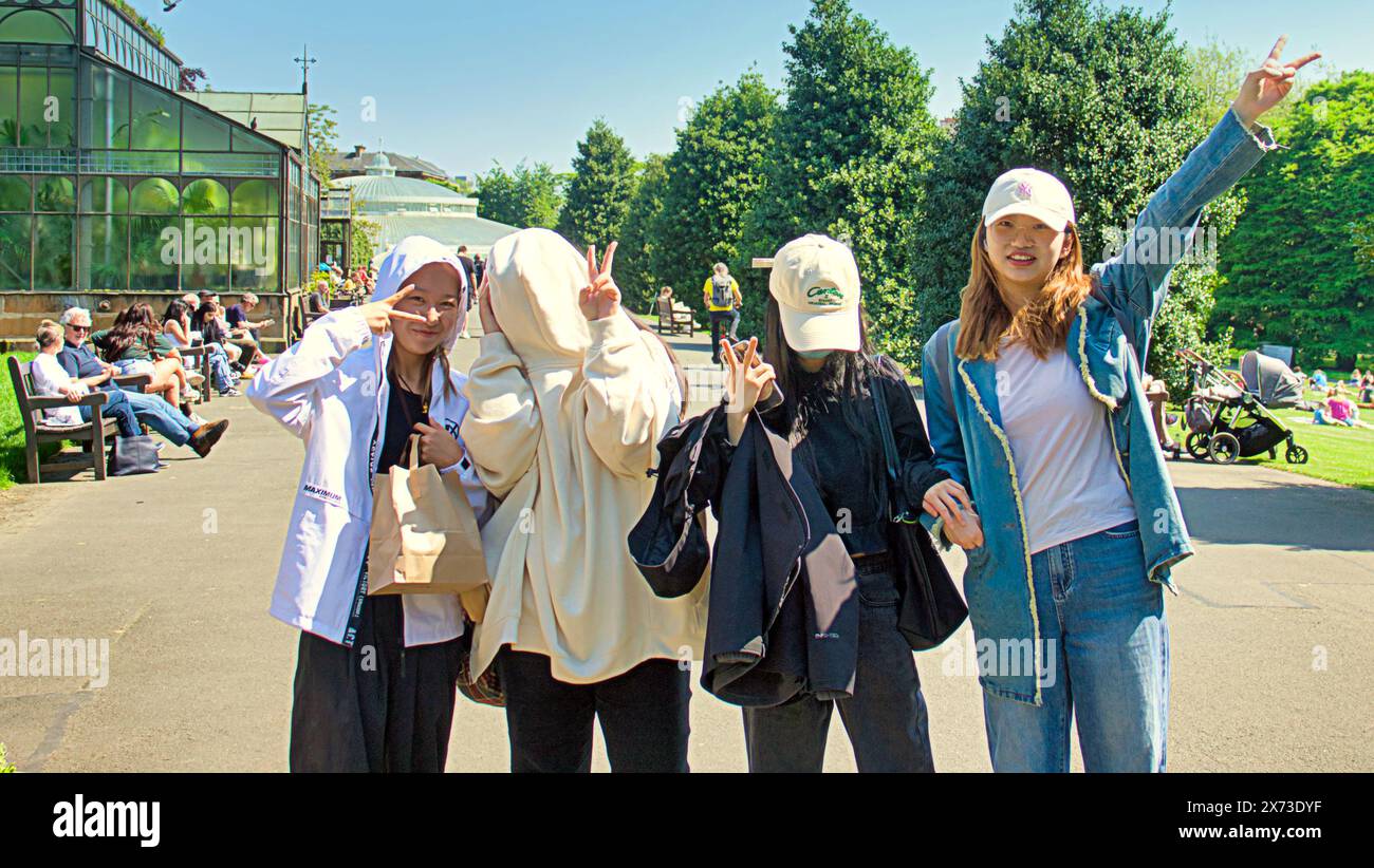 Glasgow, Scotland, UK. 17th May, 2024: UK Weather:  chinese students suffer as they hide from the sun. Scorching hot weather saw an arrival of summer as  locals and tourists in the city  took to the botanics public park with its imposing glasshouse on great western road in the west end. Credit Gerard Ferry/Alamy Live News Stock Photo